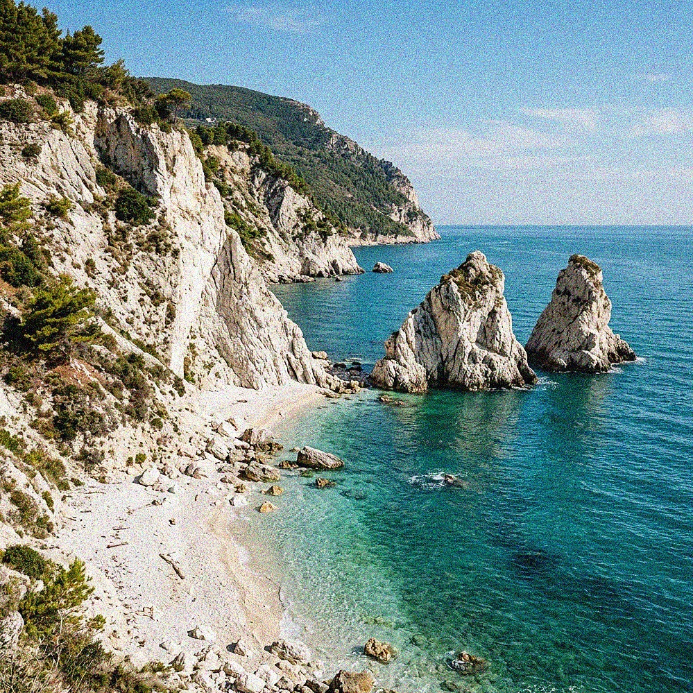 The Spiaggia delle Due Sorelle in Sirolo with dramatic white cliffs and turquoise water.
