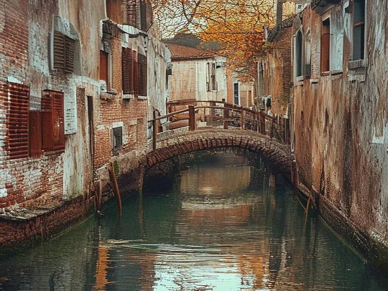 A quiet secondary canal in Venice with reflections on the water and historic facades